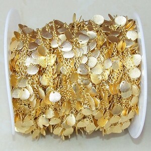 May include: A spool of gold-colored chain with small, scalloped metal charms. The chain is perfect for jewelry making or adding a decorative touch to crafts.
