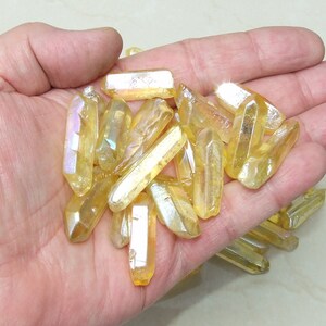 May include: A collection of iridescent yellow crystal points, also known as golden healer crystals, in various sizes and shapes.