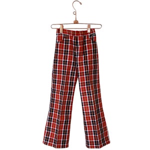 May include: Red, black, and white plaid pants with a wide leg, hanging on a wooden hanger.