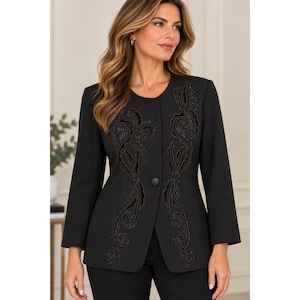 May include: A black blazer featuring a round neckline, long sleeves, and a single-button closure. The front is decorated with intricate black velvet appliqué and beadwork in a swirling, organic pattern that extends vertically along the sides.