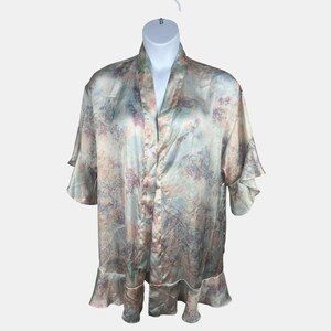 May include: A silky, floral-patterned robe in pastel colors of blue, pink, and lavender. The robe has a ruffled hem and sleeves, and is displayed on a white mannequin. The robe is open in the front.