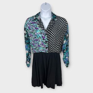 May include: A vintage dress with a black skirt and a collared top. The top is split, with one side featuring a floral pattern in purple, teal, and blue, and the other side with white polka dots on a black background. The dress has long sleeves.