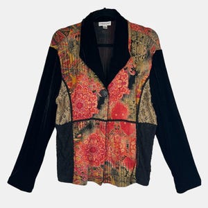 May include: A patterned blazer with black velvet sleeves and collar. The front features a floral design in red, gold, and black. The blazer has a single button closure and a lace panel on the sides.