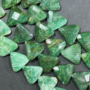 May include: A strand of green triangle-shaped gemstone beads. The beads are faceted and have a natural, organic look.
