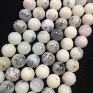 May include: A strand of white and gray agate beads. The beads are round and have a smooth, polished finish. The beads are strung on a clear elastic cord.
