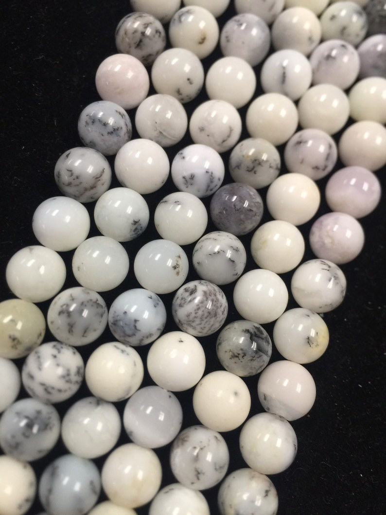 May include: A strand of white and gray agate beads. The beads are round and have a smooth, polished finish. The beads are strung on a clear elastic cord.