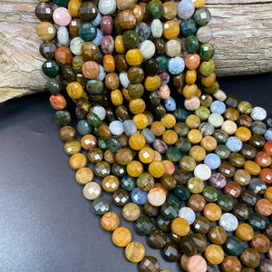 May include: A strand of multi-colored gemstone beads. The beads are round and faceted, with a variety of colors including brown, green, yellow, and red. The beads are strung on a clear cord.