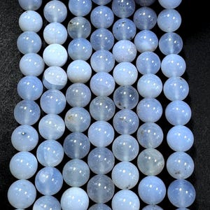 Pu&ograve; includere: Una collana di perle di agata blu chiaro. Le perle sono rotonde e lisce, con un aspetto leggermente traslucido.