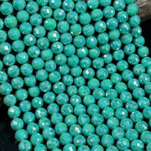 May include: A strand of turquoise blue faceted glass beads. The beads have a slightly iridescent finish.