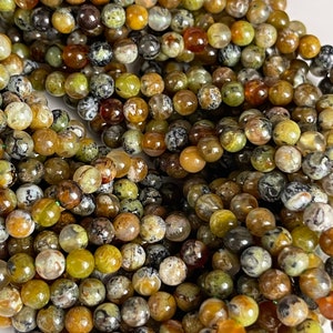 Op de afbeelding: Een streng ronde, groene, bruine en witte agaat kralen. De kralen zijn ongeveer 6 mm in diameter en hebben een natuurlijke, gepolijste afwerking.