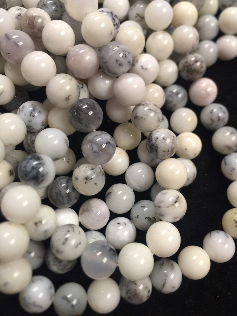 May include: A strand of white and gray opal beads. The beads are round and have a smooth, polished finish. They are perfect for making jewelry or other crafts.