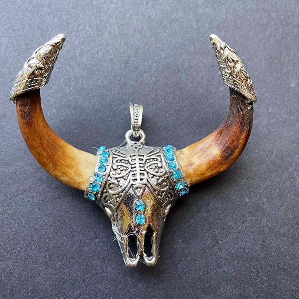 Beau pendentif dents de loup. Forme de longue corne faite main. Superbe couleur brune avec pendentif en forme de dent en plaqué argent. Avec perle cristal bleu