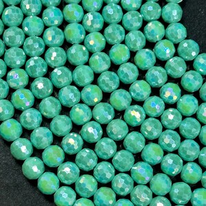 May include: A strand of iridescent green faceted glass beads. The beads are round and have a smooth, polished finish.