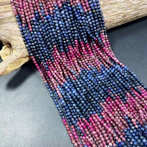 May include: Strands of faceted beads in shades of deep blue and magenta. The beads are strung together, creating a textured and colorful display. The beads are likely for jewelry making.