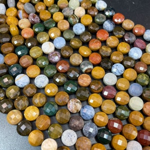 May include: A strand of multi-colored gemstone beads, each bead is faceted and round, with a variety of colors including brown, green, red, and blue.