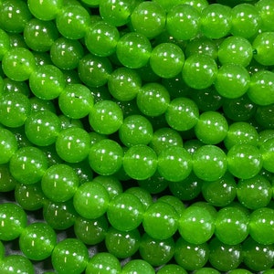 May include: A strand of bright green jade beads. The beads are round and smooth, and they have a glossy finish.