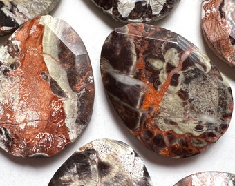 Puede incluir: Siete piedras ovaladas pulidas con un patrón único de marrón, blanco y gris. Las piedras tienen una superficie lisa y pulida y una forma ligeramente irregular.