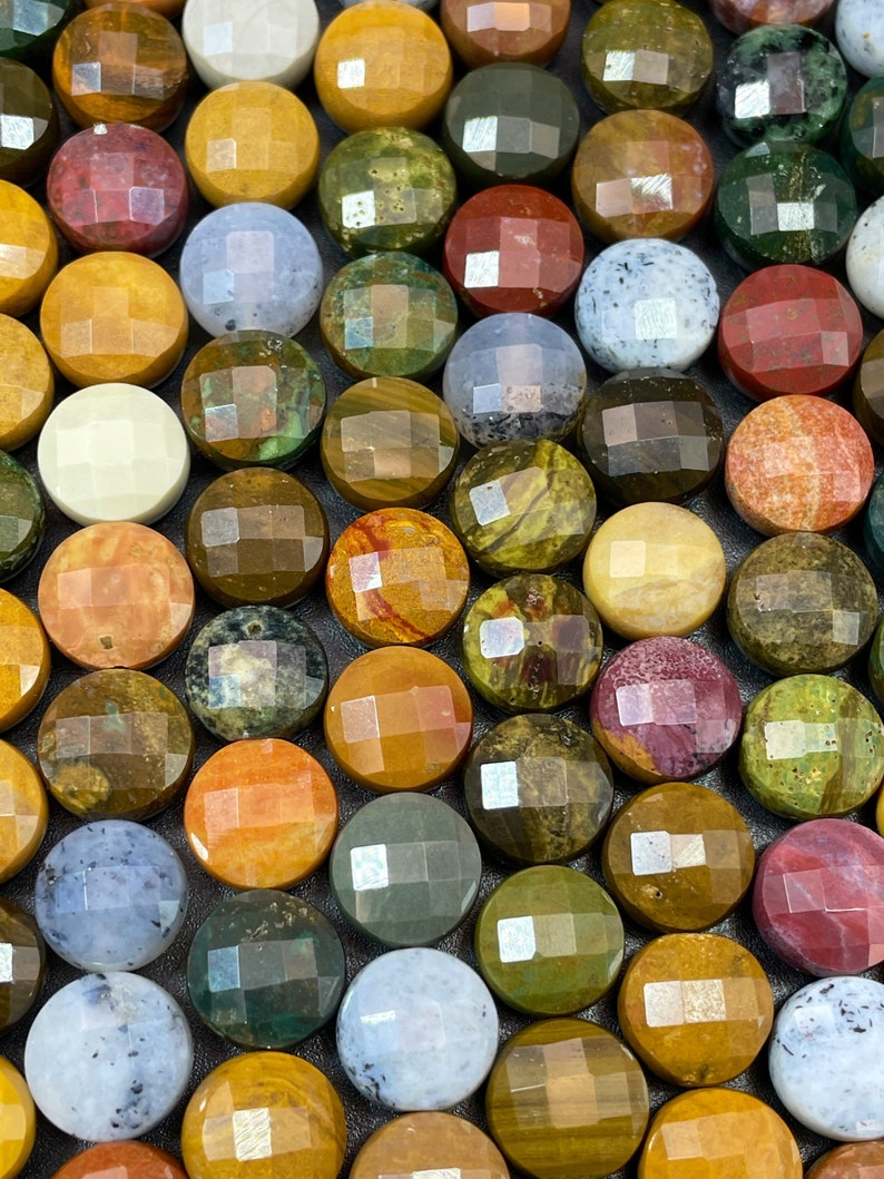 May include: A collection of round, faceted gemstone cabochons in various colors and patterns, including green, brown, yellow, red, and white.