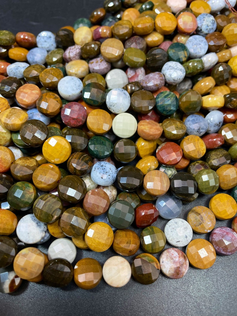 May include: A strand of round, faceted gemstone beads in various shades of brown, green, yellow, red, and white. The beads are approximately 10mm in diameter and have a polished, shiny finish.