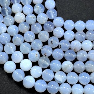 Pu&ograve; includere: Una collana di perle di agata blu chiaro. Le perle sono rotonde e lisce, con un aspetto leggermente traslucido.
