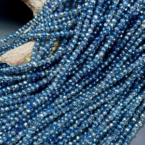 May include: A strand of dark blue faceted glass beads. The beads are small and have a shiny, iridescent finish.