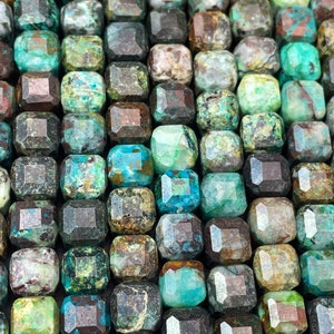 Puede incluir: Una hebra de cuentas de piedras preciosas verdes, marrones y azules. Las cuentas son de forma cuadrada y tienen un acabado facetado.