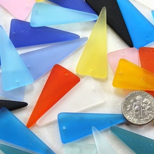 May include: Assortment of colorful frosted glass triangle pendants with a hole at the top. The pendants are various shades of blue, yellow, orange, red, pink, and black. A US dime is included for scale.