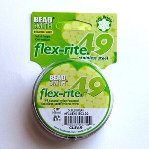 May include: A spool of clear Bead Smith Flex-Rite 49 strand nylon-coated stainless steel micro-wire. The spool is labelled with the brand name, product name, and size: 0.018 inches (45 mm), 24.6 lb break, #FL49X018CL30, 30 ft (9.14 m).