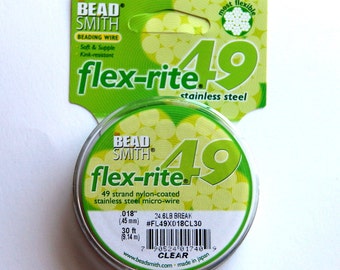 Op de afbeelding: Een spoel met Bead Smith Flex-Rite 49-strengs nylon-gecoate roestvrijstalen microdraad, in de kleur transparant. De spoel is voorzien van een label met de merknaam, productnaam en maat: 0,018 inch (45 mm), breeksterkte 24,6 lb, #FL49X018CL30, 30 ft (9,14 m).