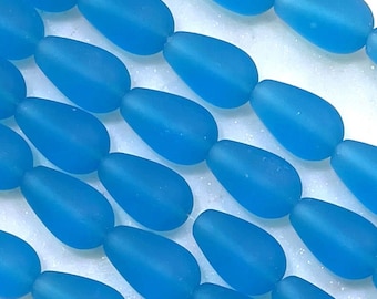 May include: A strand of turquoise blue glass beads in a teardrop shape.