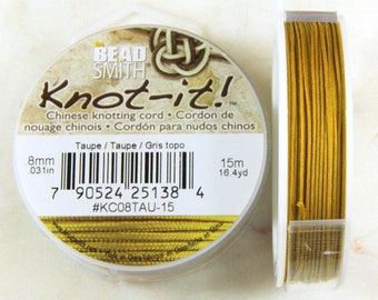 Op de afbeelding: Een spoel taupekleurige Knot-it! Chinese knoopdraad. De spoel is gelabeld met de merknaam "The Bead Smith" en de productnaam "Knot-it!" De spoel is 15 meter (16,4 yard) lang en 8 millimeter (0,31 inch) dik.