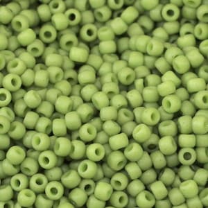 May include: A close-up image of a large quantity of small, round, light green beads. The beads are all the same size and shape, and they are arranged in a random pattern.