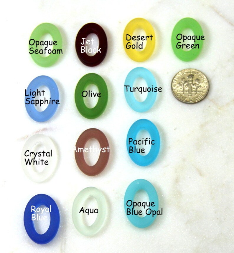 May include: Assortment of 14 oval-shaped glass beads in various colors, including opaque seafoam, jet black, desert gold, opaque green, light sapphire, turquoise, olive, amethyst, pacific blue, crystal white, royal blue, aqua, and opaque blue opal.