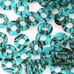 May include: A collection of teal glass beads with black stripes. The beads are shaped like rings with a hole in the center.