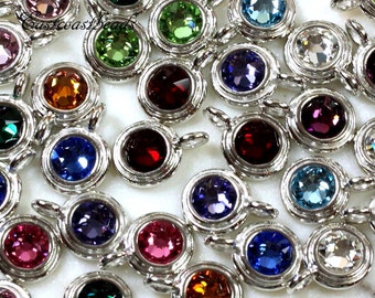 May include: Assortment of silver-toned charms with colourful crystal accents. Each charm features a round crystal in a variety of colours, including red, blue, green, purple, and clear. The charms have a loop for attaching to jewellery or other crafts.