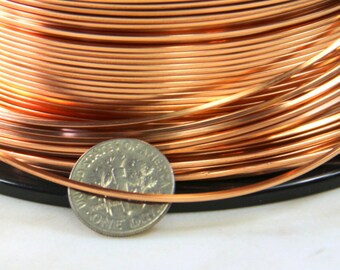 May include: A spool of copper wire with a US penny for scale. The wire is shiny and has a warm, reddish-brown color.