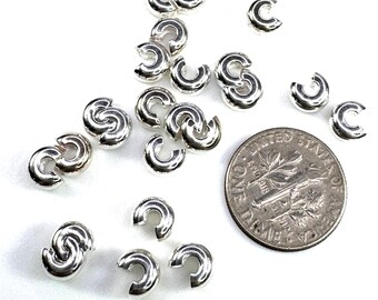 May include: Silver-toned metal jump rings, approximately the size of a US dime, for jewelry making.