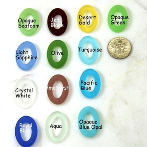 May include: Assortment of 14 oval-shaped glass beads in various colors, including opaque seafoam, jet black, desert gold, opaque green, light sapphire, turquoise, olive, amethyst, pacific blue, crystal white, royal blue, aqua, and opaque blue opal.