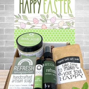 May include: A gift box with a "Happy Easter" sign, containing body scrub, artisan soap, bath salt soak, and other self-care products. The products are labeled "Refresh" and "Lime Wild Mint". The box includes a sprig of mint.