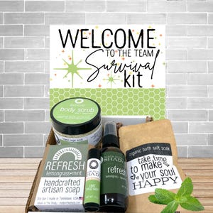 May include: A gift box labeled "Welcome to the Team Survival Kit" with various self-care products. Includes a body scrub, soap, lip balm, spray, and bath salt. The products are labeled with "Refresh" and "Made in the Shady" branding.