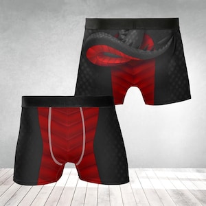 May include: Black and red boxer shorts with a geometric design. The shorts have a black waistband and a red panel with a chevron pattern. One pair features a red and black dragon design on the back.