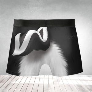 May include: Black and white boxer briefs featuring a skunk design. The underwear has a black waistband and a detailed illustration of a skunk's fur and tail. The design is printed on a soft fabric.