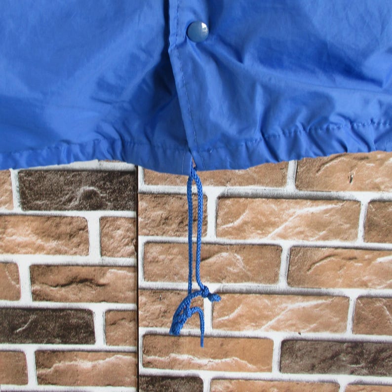 Pode incluir: Uma jaqueta azul com um cord&atilde;o de ajuste na parte inferior. O cord&atilde;o &eacute; feito de um cord&atilde;o azul.