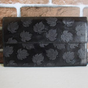 Cartera vintage Peruzzi de cuero negro con múltiples bolsillos, ranura para tarjetas, monedas, billetes y hojas de parra en relieve.