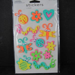 May include: A package of colorful foam stickers featuring various designs, including ladybugs, flowers, butterflies, and a heart. The stickers are in bright shades of orange, pink, green, and yellow. The package reads "stickers" and "1 count".