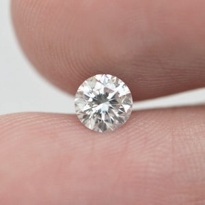 May include: A clear round diamond gemstone with facets.
