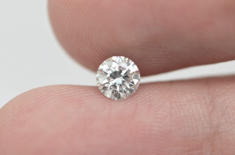 May include: A clear round diamond gemstone with facets.