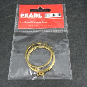 Puede incluir: Un paquete que contiene cinco bases redondas para candelabros. Las bases son de metal color oro y est&aacute;n en una bolsa de pl&aacute;stico transparente. El paquete tiene una etiqueta roja con la marca "PEARL".