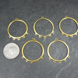 Puede incluir: Cinco aros de pendientes de metal color lat&oacute;n con peque&ntilde;os bucles para sujetar cuentas o abalorios. Cada aro tiene un peque&ntilde;o bucle en la parte superior para colgar. Una moneda est&aacute; al lado de los aros para comparar el tama&ntilde;o.