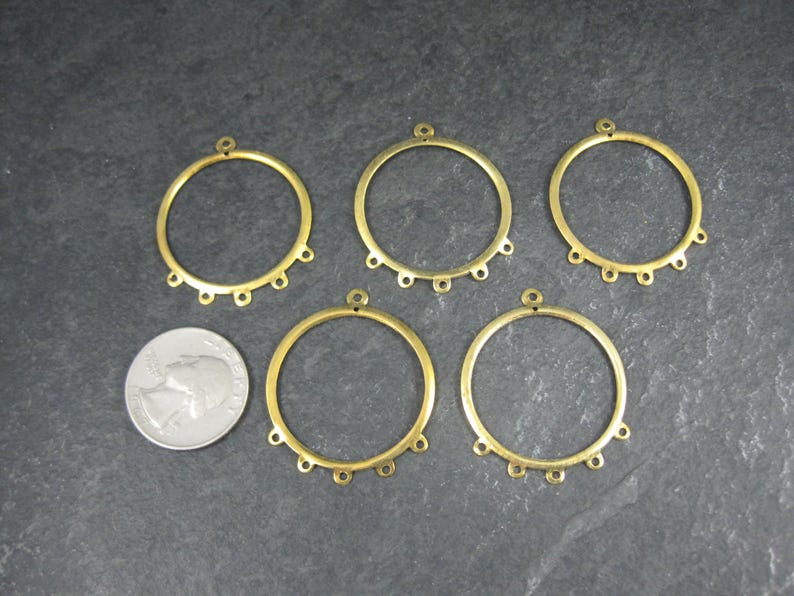 Puede incluir: Cinco aros de pendientes de metal color lat&oacute;n con peque&ntilde;os bucles para sujetar cuentas o abalorios. Cada aro tiene un peque&ntilde;o bucle en la parte superior para colgar. Una moneda est&aacute; al lado de los aros para comparar el tama&ntilde;o.